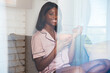 © David Prado/Stocksy - Smiling black woman with bowl of cereals through glass