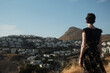 © Lucia Postike/Stocksy - Woman looking at mountain landscape with houses