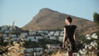 © Lucia Postike/Stocksy - A woman stands on the background of the city near the mountain