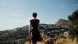 © Lucia Postike/Stocksy - Figure of a woman admiring a coastal city from above