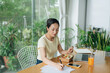 © Marc Tran/Stocksy - Busy young business woman eating a healthy lunch while working