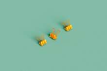 Three Yellow Paperclip On Green Background