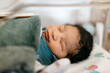© Kristen Curette & Daemaine Hines/Stocksy - A newborn baby boy swaddled in a blanket