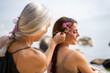 © Alba Vitta/Stocksy - Mother braiding hair to daughter at the beach