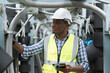 © amorn - Male plumber engineer worker work with digital tablet in sewer pipes area at construction site. African American male engineer worker check or maintenance sewer pipe network system at construction sit