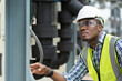 © amorn - African American male plumber worker check or maintenance sewer pipes network system at construction site
