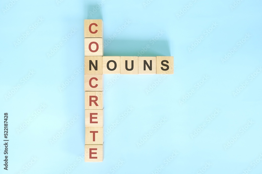 Concrete nouns concept in English grammar noun education. Wooden block