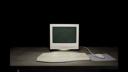 Old dirty computer monitor sitting on a dark table on a black background. With a vintage mouse, mousepad and keyboard. 3D rendering