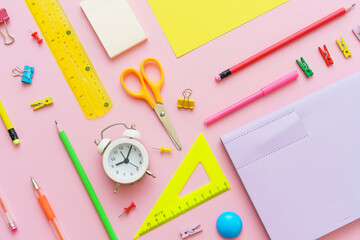 School supplies, stationery on pink background. Pens pencils notepad. Flat lay, top view. Back to school concept