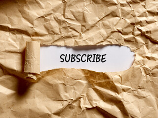 Wall Mural - The word subscribe written under a brown torn paper. Membership, registration or subscription
