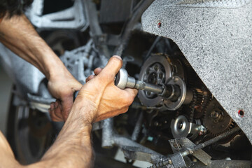 Wall Mural - Mechanic repairing engine of motorcycle. Concept of motorcycle maintenance