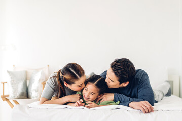 Portrait of enjoy happy love asian family father and mother holding hug cute little asian girl child smiling play and having fun moments good time in at home.