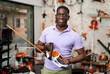 © JackF - African-american man with electric shears standing in gardening tool store.