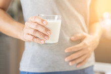 Pain, Allergy Young Asian Woman, Girl Hand In Belly Suffer After Drink Glass Of Milk, Unhappy And Bad Stomach Ache. Lactose Intolerance And Dairy Food , Health Problem Concept.