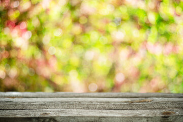 Wall Mural - Old wooden table top and blurred colorful autumn background.