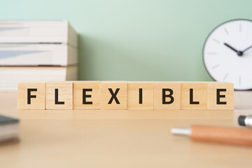 フレキシブル・柔軟のイメージ｜「FLEXIBLE」と書かれたブロックが置かれたデスク
