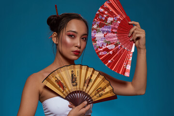 Serious elegant asian girl with handheld fans