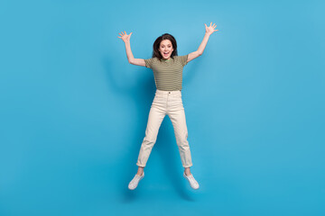 Wall Mural - Full size photo of funky young brunette lady jump wear casual cloth isolated on blue background