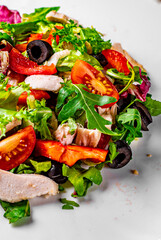 Wall Mural - Fresh salad with chicken breast, arugula, black olives,red pepper, lettuce, fresh sald leaves and tomato on a white plate