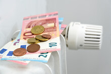 Euro Banknotes And Coins On A Heating Radiator, Concept For Rising Energy Prices And Inflation, Copy Space, Selected Focus