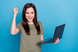 Leinwandbild Motiv Photo of hooray young brunette lady work laptop wear striped t-shirt isolated on blue color background