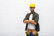 © LIGHTFIELD STUDIOS - Cheerful arabian repairman in hardhat crossing arms at home