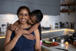 UK, London, Girl embracing mother in kitchen