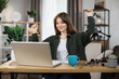 © sofiko14 - Excited caucasian businesswoman sitting at table with modern laptop and keeping arms raised for celebrating good news at work. Concept of success.