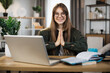 © sofiko14 - Smiling caucasian woman in casual wear sitting on workplace on yoga pose relaxing during break after working with modern laptop. Pretty female freelance meditating with open eyes.