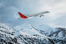 Commercial Plane Flying Over The Snowy Mountains