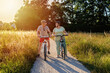 Happy smiling senior couple riding bicycles together outdoors in countryside at warm sunny day.