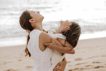 Loving Mother Embracing Cute Daughter On Sandy Seashore