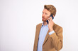 © KAMPUS - Portrait of serious businessman talking on mobile phone. Caucasian man wearing blue shirt and beige woolen suit coat talking to client on smartphone. Communication and technology concept