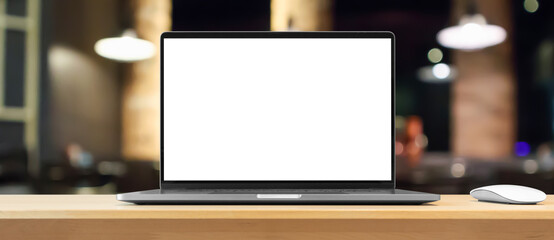 Laptop with blank screen on wood table with cafe coffee shop blur background