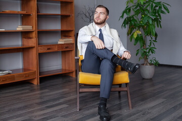 Wall Mural - Young man relaxing and sitting on armchair