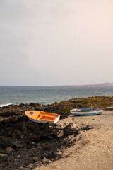 Two small fishing boats on the shore at sunset