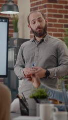 Wall Mural - Vertical video: Close up of worker presenting business strategy on display with data analysis, working on company growth and development with colleagues. Man talking to workmates about project