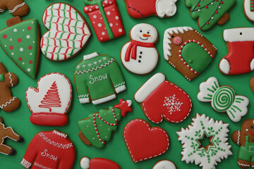 Different Christmas gingerbread cookies on green background, flat lay