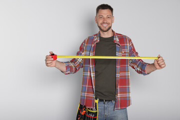 Sticker - Handsome worker with measuring tape on white background