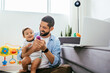 © kleberpicui - Father working with his baby boy in home office with laptop. Work from home concept