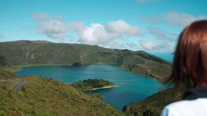 Wall Mural - Woman looking to the landscape nature of the Fire Lagoon (Lagoa do Fogo) background enjoying vacation travel adventure in the Island of São Miguel in the Azores.