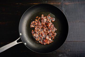 Wall Mural - Diced Bacon Rendered in a Large Skillet Viewd from Above: Small pieces of bacon sizzling in a nonstick skillet