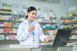 © tonefotografia - Female pharmacist counseling customer via video call in a modern pharmacy drugstore.