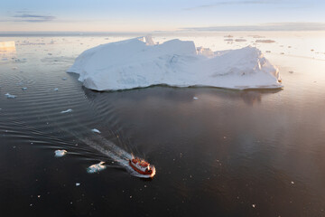 Wall Mural - Small ship cruising among ice bergs during beautiful summer day. Disko Bay, Greenland.
Climate change and global warming.