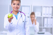 © lenets_tan - Female doctor hand holding a green apple, sitting