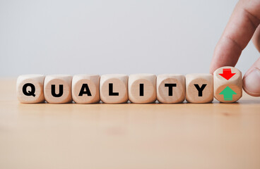 Fototapete - Hand flipping between green up arrow and red down arrow with quality wording for product and service increase and decrease quality concept.