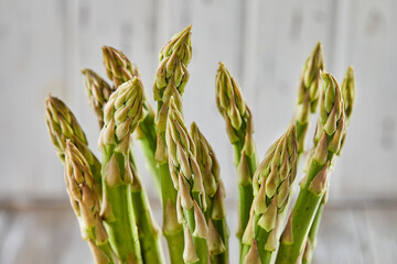 Poster - Asparagus on a light wooden background for cooking.