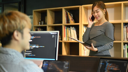  Young developers or coder team working together on software design project at modern office