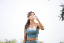 Athlete Young Beautiful Woman Drinking Water From A Plastic Bottle At Summer Green Park, Sport Woman Drinking Water After Work Out Exercising