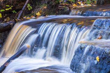 Canvas Print - Flowing water in a creek at autumn